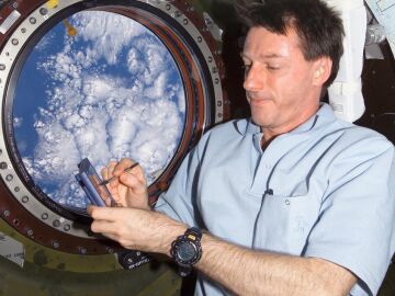 El astronauta Michael Foale escribiendo en la Estación Espacial Internacional