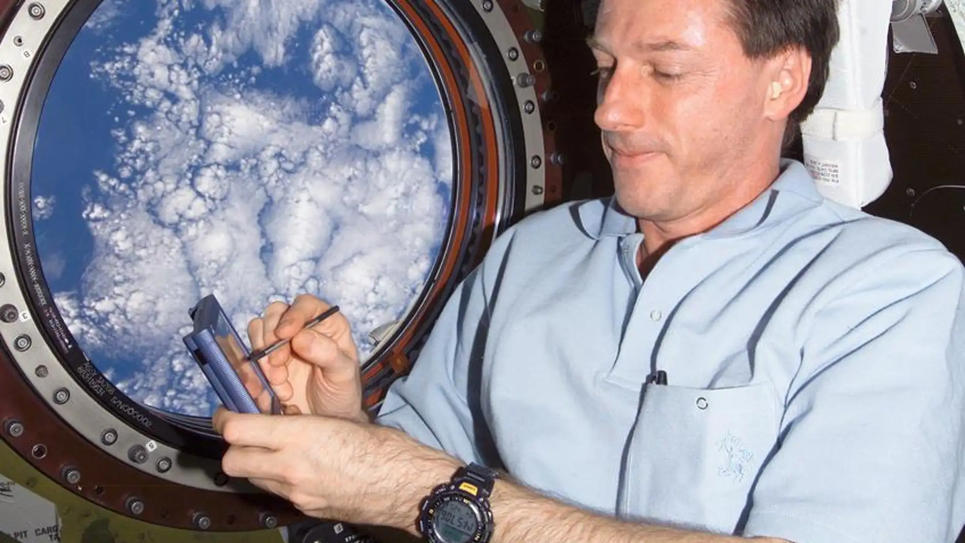 El astronauta Michael Foale escribiendo en la Estación Espacial Internacional