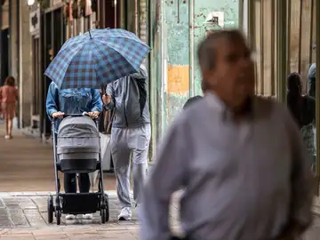 Una pareja se protege de la lluvia en Logroño.