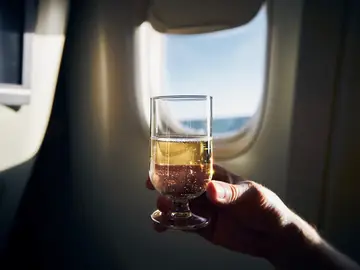 Pasajero bebiendo cerveza en el avión