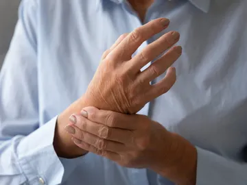 Señora mayor masajeando la mano que sufre de concepto de artritis reumatoide Señora mayor masajeando la mano que sufre de concepto de artritis reumatoide