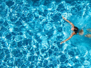 Chica joven nadando en una piscina