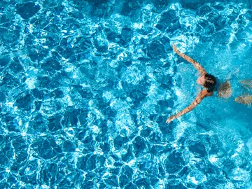 Chica joven nadando en una piscina Chica joven nadando en una piscina