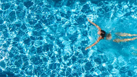 Chica joven nadando en una piscina Chica joven nadando en una piscina