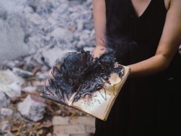 Mujer sosteniendo un libro quemado