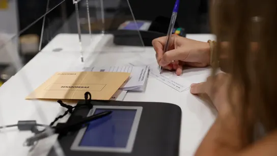 Una mujer cumplimenta la documentación para ejercer el voto por correo en una oficina de Madrid Una mujer cumplimenta la documentación para ejercer el voto por correo en una oficina de Madrid