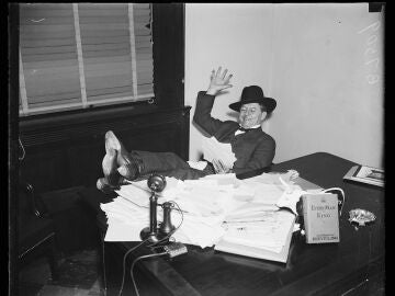 Un hombre sentado en su despacho en los años 30 con la biografía de Huey Long en su mesa
