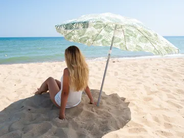 Mujer a la sombra de una sombrilla Mujer a la sombra de una sombrilla