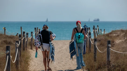 Dos personas se dirigen a la playa de El Saler Dos personas se dirigen a la playa de El Saler