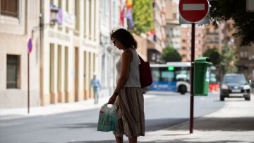 Imagen de archivo. Una vecina espera al autobús a la sombra en Albacete.
