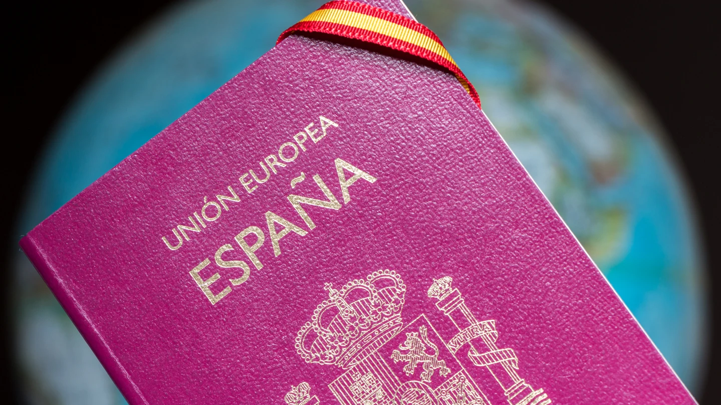 Imagen de un pasaporte español. Imagen de un pasaporte español con una cinta con la bandera de España.
