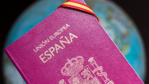 Imagen de un pasaporte español. Imagen de un pasaporte español con una cinta con la bandera de España.