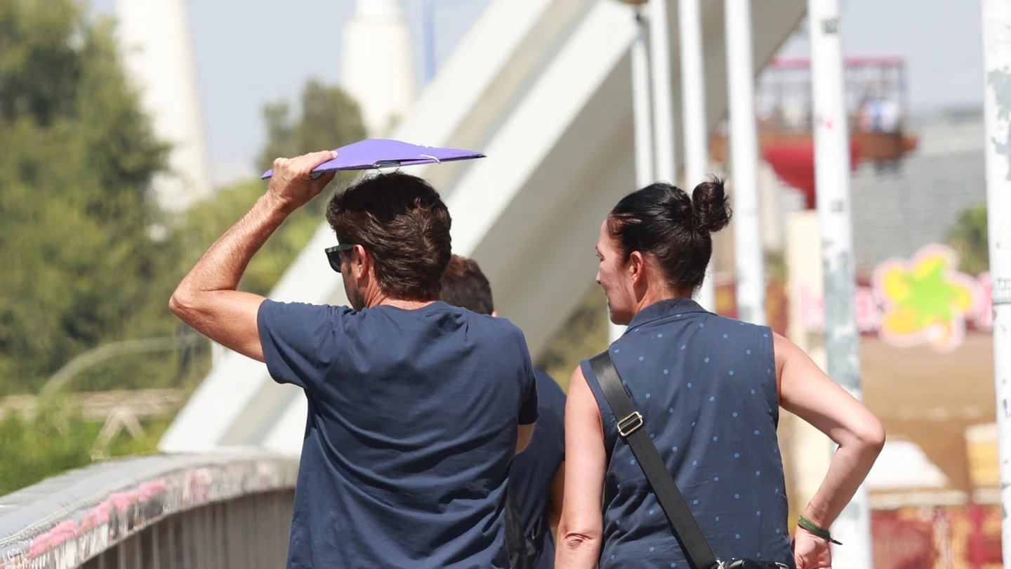 Un hombre cruza el puente de la Barqueta usando una carpeta para protegerse de las altas temperaturas, a 24 de agosto en Sevilla (Andalucía, España). La ola de calor acaba este jueves con la llegada de una vaguada que bajará las temperaturas. Un hombre cruza el puente de la Barqueta usando una carpeta para protegerse de las altas temperaturas, a 24 de agosto en Sevilla (Andalucía, España). La ola de calor acaba este jueves con la llegada de una vaguada que bajará las temperaturas.