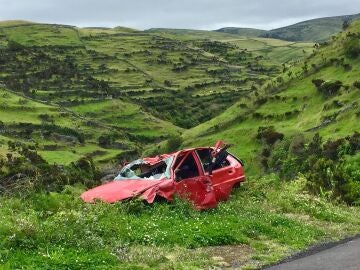 Coche accidentado en la cuneta de una carretera comarcal.