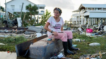 Jewell Baggett, 51, sitting in a bathtub in the rubble of the house built by her grandfather.
