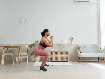 Mujer practicando sentadillas Mujer practicando sentadillas