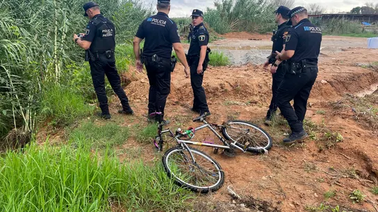 La Policía Local de paterna junto a la bicicleta del hombre arrastrado por el agua que intentó cruzar un barranco en Paterna La Policía Local de paterna junto a la bicicleta del hombre arrastrado por el agua que intentó cruzar un barranco en Paterna