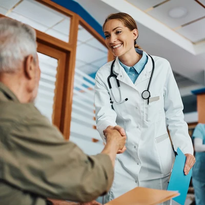 Un médico saluda a una persona mayor en la sala de espera