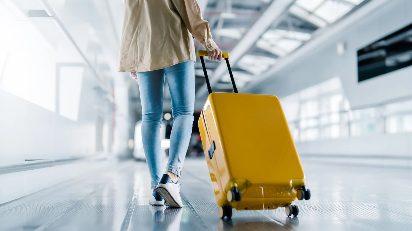 Chica joven con la maleta en el aeropuerto Chica joven con la maleta en el aeropuerto