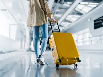 Chica joven con la maleta en el aeropuerto Chica joven con la maleta en el aeropuerto