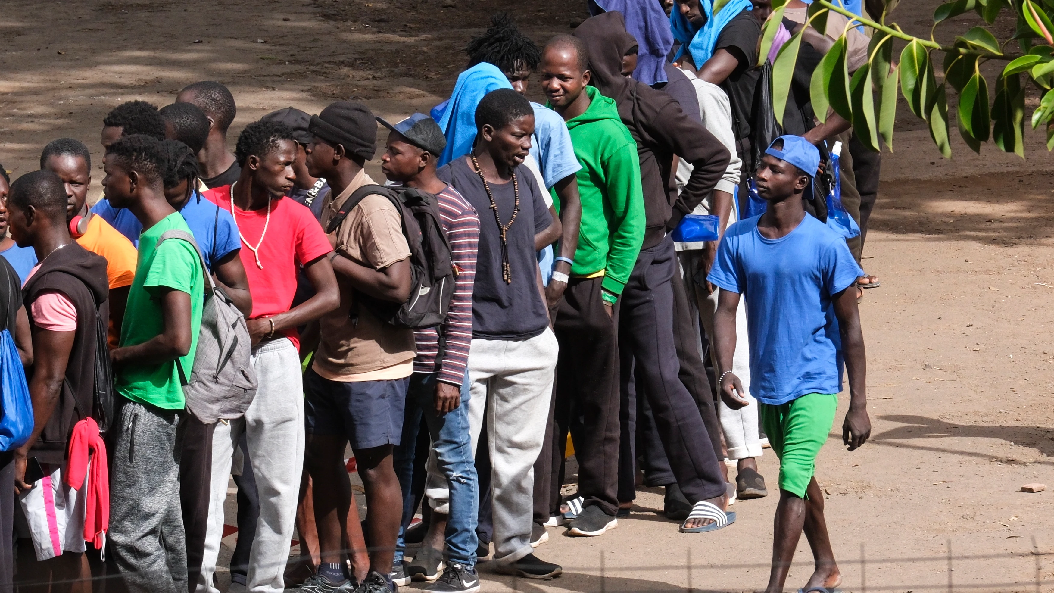 Varias decenas de inmigrantes hacen cola en el interior centro de acogida de Las Raíces, en La Laguna (Tenerife)