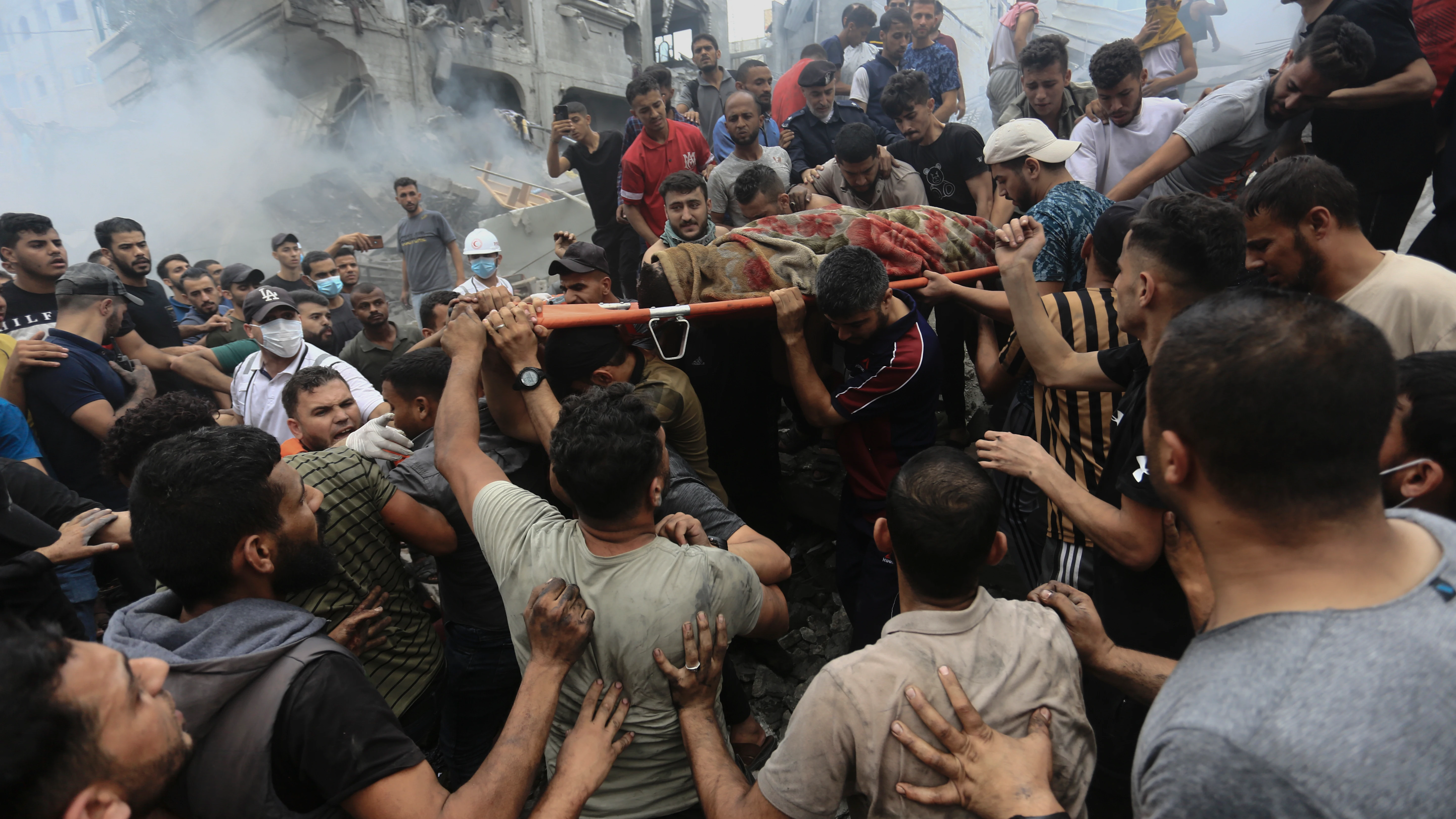 Palestinos llevan un cadáver tras la respuesta de Israel a los ataques de Hamás en la Franja de Gaza