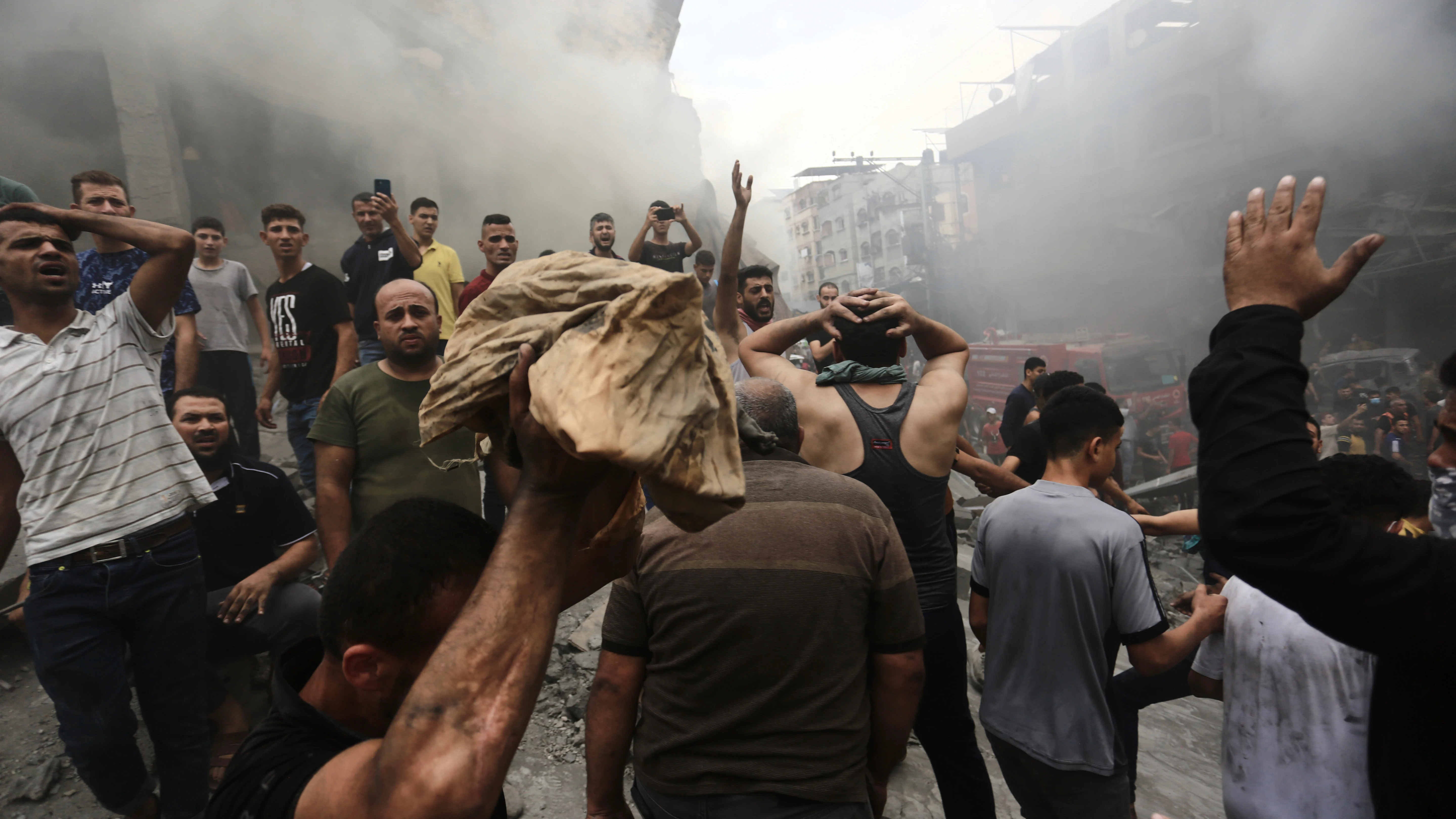 Palestinos reaccionan después de hallar un cadáver entre los escombros de un edificio después de un ataque israelí en la Franja de Gaza