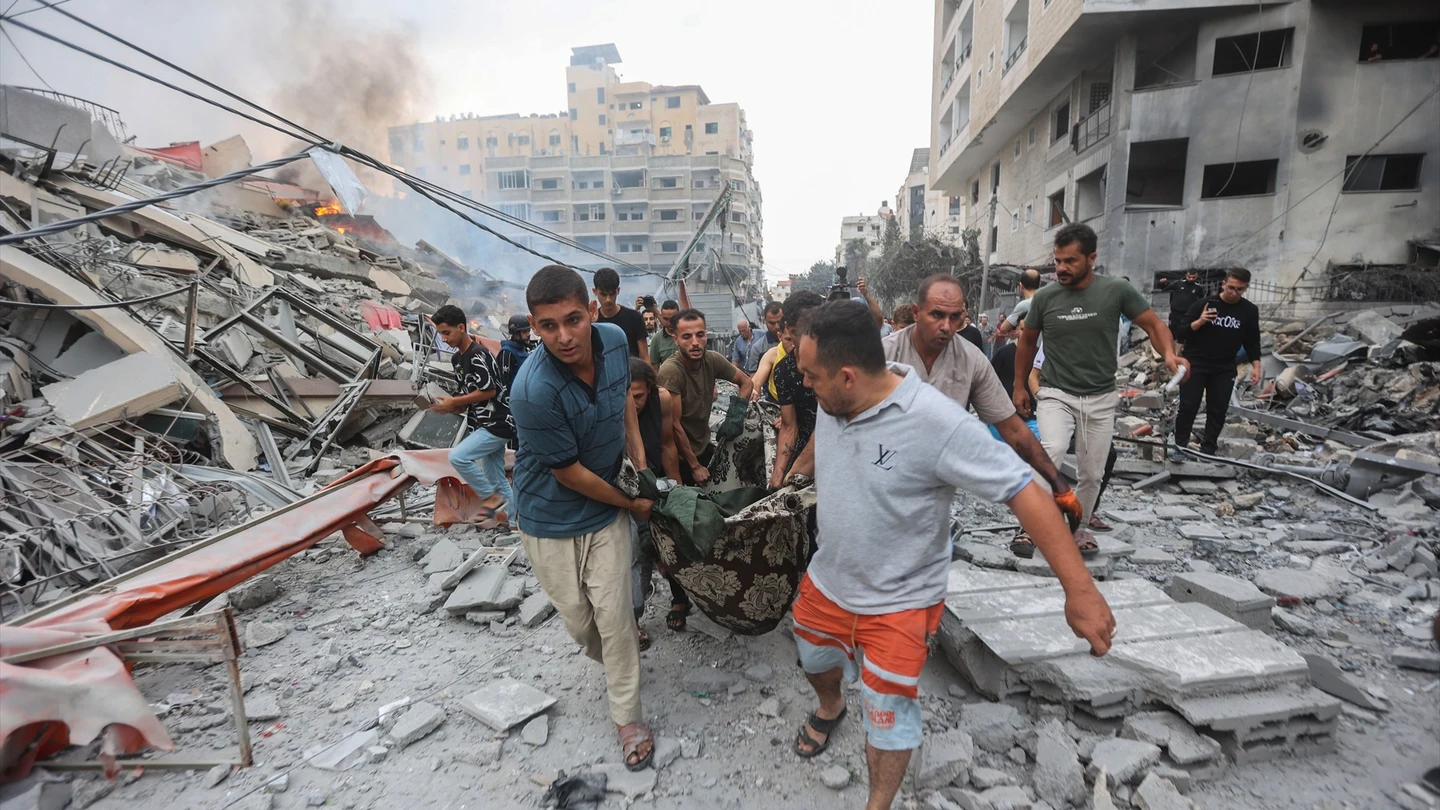 Palestinos cargan el cuerpo de un hombre muerto después de los ataques israelíes, tras un ataque sorpresa de Hamás. Palestinos cargan el cuerpo de un hombre muerto después de los ataques israelíes, tras un ataque sorpresa de Hamás.