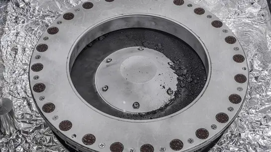 Fragmentos del asteroide Bennu traídos a la Tierra por la misión de la NASA OSIRIS-REx, vistos en la parte externa del recolector de muestras de la sonda Fragmentos del asteroide Bennu traídos a la Tierra por la misión de la NASA OSIRIS-REx, vistos en la parte externa del recolector de muestras de la sonda