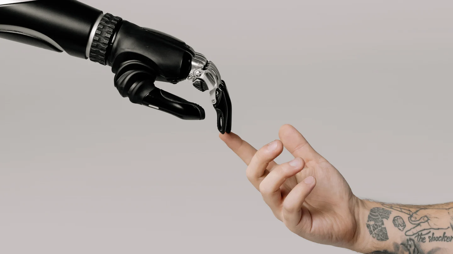 Una mano robótica roza una mano humana 'Poder y progreso', o cómo la tecnología marca el paso de desigualdades y riquezas