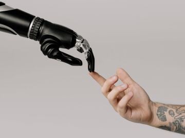 Una mano robótica roza una mano humana