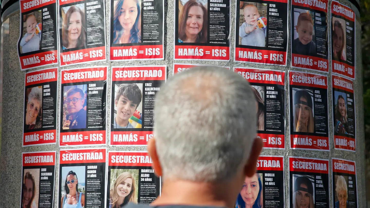 Una persona observa carteles con rostros de israelíes secuestrados en Gaza. Una persona observa carteles con rostros de israelíes secuestrados en Gaza.