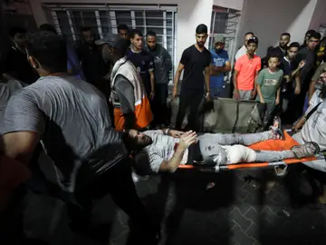 Ciudadanos palestinos intentan evacuar a uno de los heridos por el bombardeo de Israel contra un hospital de la Franja de Gaza