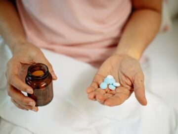 Una mano con pastillas de medicamentos.