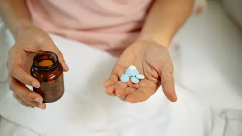Una mano con pastillas de medicamentos. Una mano con pastillas de medicamentos.