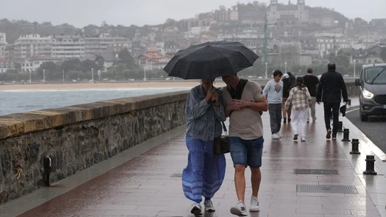 Imagen de archivo. Personas paseando bajo la lluvia. Imagen de archivo. Personas paseando bajo la lluvia.