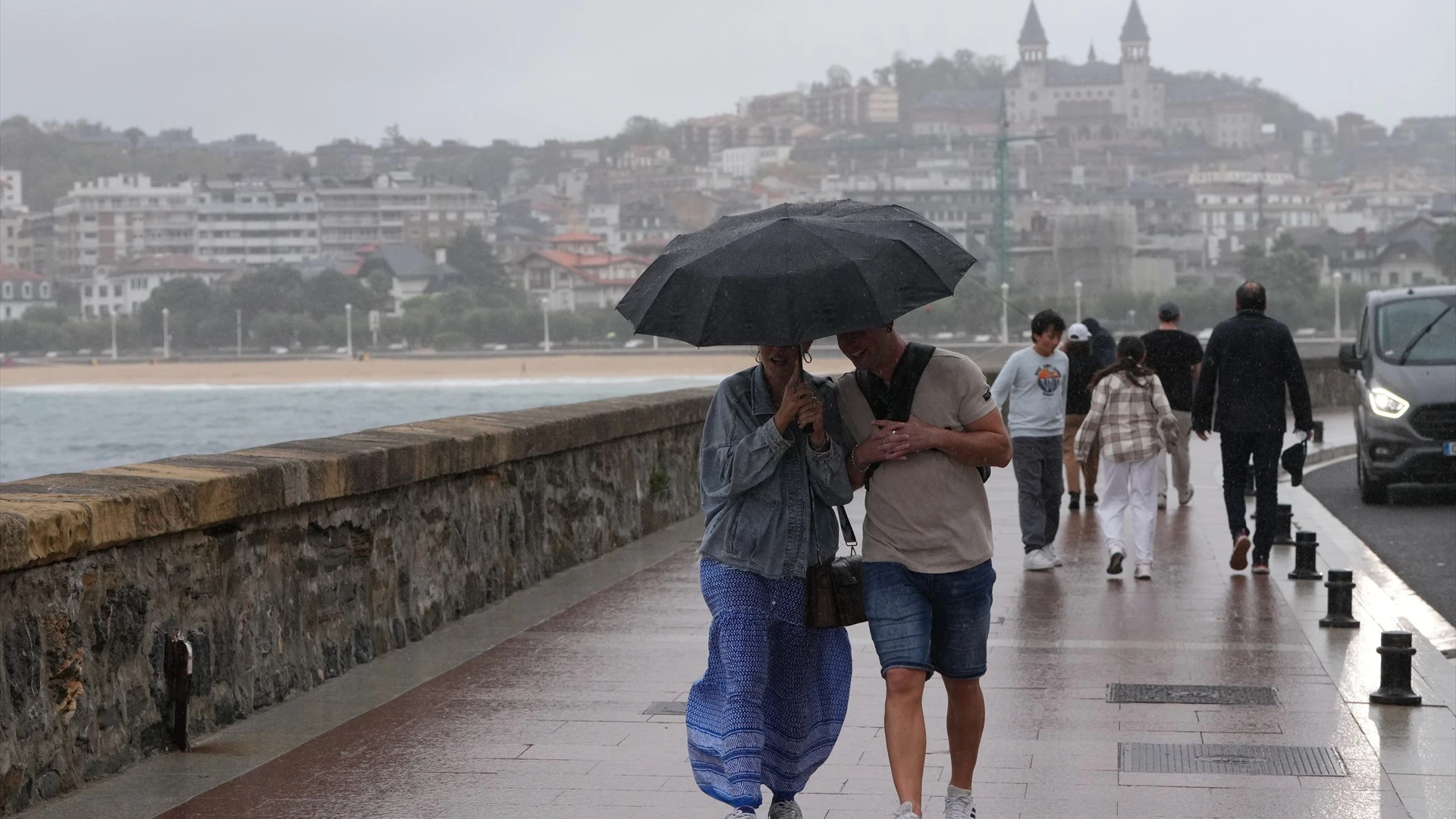 Imagen de archivo. Personas paseando bajo la lluvia.