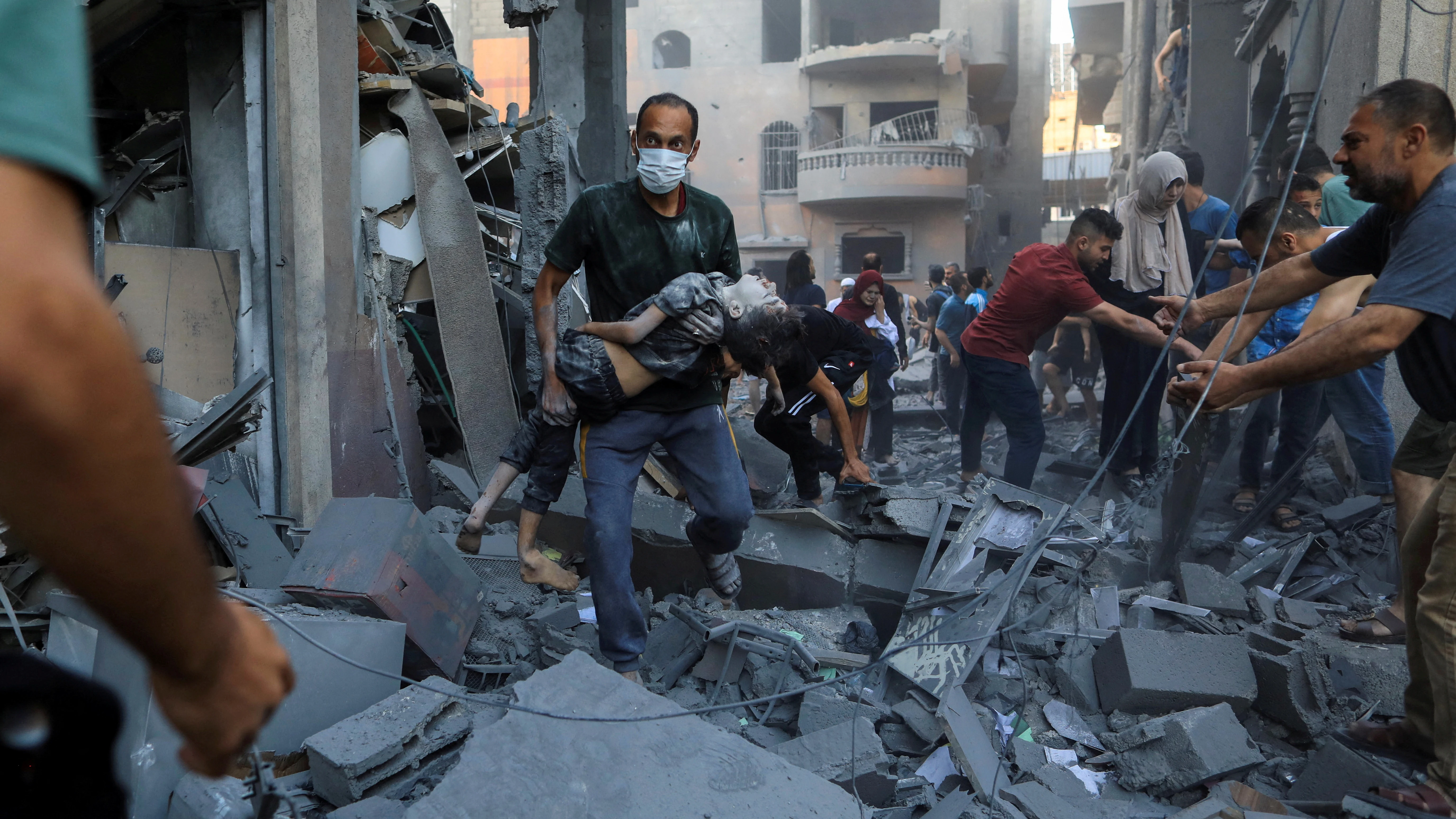 Un hombre carga a un niño herido en Khan Younis, en el sur de la Franja de Gaza