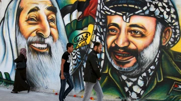 A la izquierda, la imagen del líder de Hamás, Ahmed Yasín; a la derecha, la del líder de la OLP Yasir Arafat, en un mural en Gaza (Palestina) en 2012