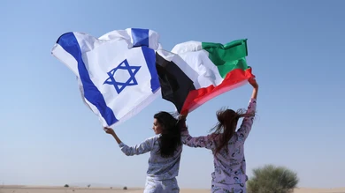 Dos mujeres, cada una con una bandera: a la izquierda, la israelí; a la derecha, la palestina Dos mujeres, cada una con una bandera: a la izquierda, la israelí; a la derecha, la palestina