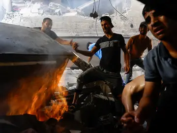 Los palestinos buscan entre escombros a sus familiares tras destruir Israel sus casas en Khan Younis, en el sur de Gaza.