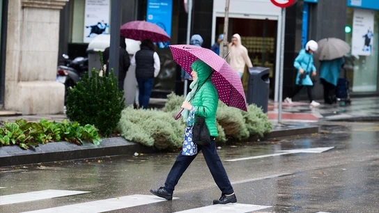 Persona caminando bajo la lluvia. Persona caminando bajo la lluvia.