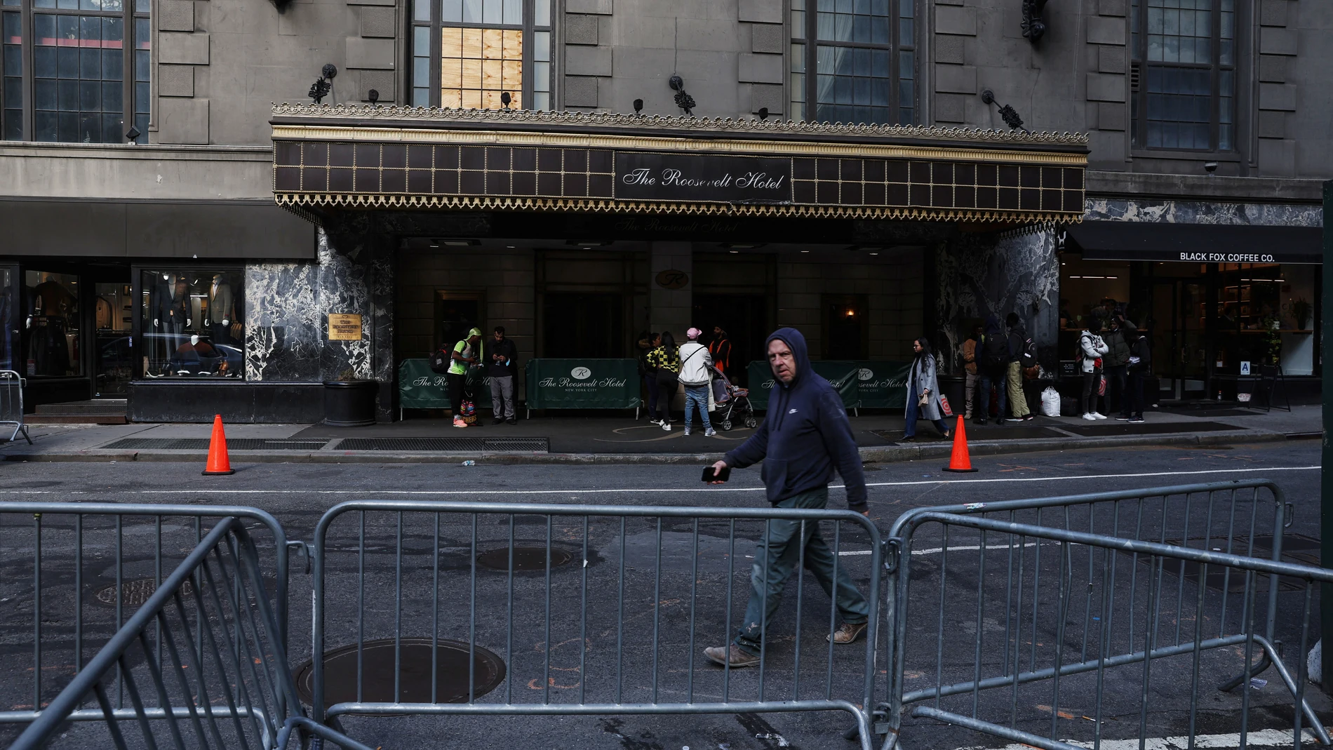 Personas hacen cola ante el Hotel Roosevelt de Nueva York, convertido en un centro de recepción de migrantes