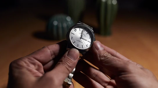 Una persona ajusta un reloj de muñeca. Una persona ajusta un reloj de muñeca.