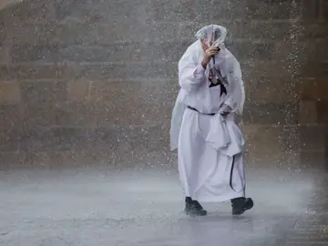 Un religioso bajo la lluvia este sábado en la plaza del Obradoiro en Santiago de Compostela