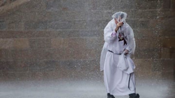 Un religioso bajo la lluvia este sábado en la plaza del Obradoiro en Santiago de Compostela
