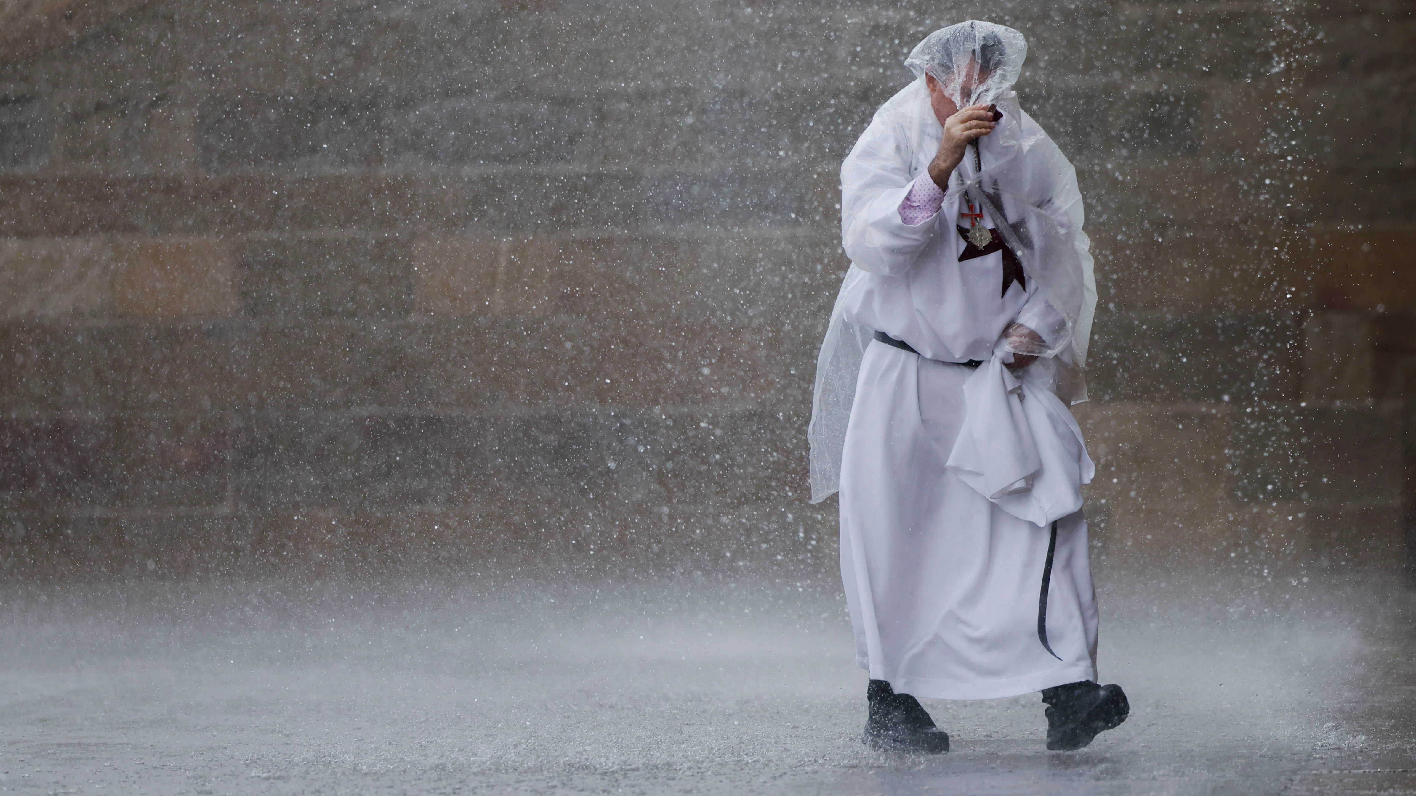 Un religioso bajo la lluvia este sábado en la plaza del Obradoiro en Santiago de Compostela