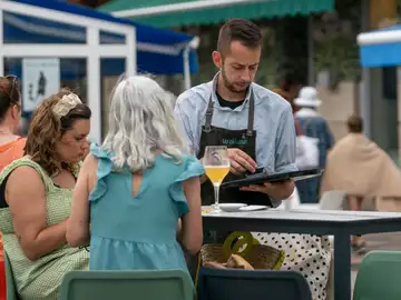 Un camarero atiende una de las mesas en una terraza de Santander.