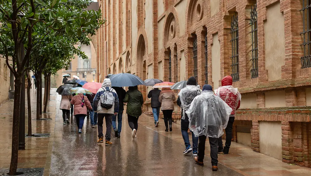 Turistas caminando por Barcelona bajo la lluvia Turistas caminando por Barcelona bajo la lluvia