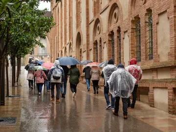 Turistas caminando por Barcelona bajo la lluvia Turistas caminando por Barcelona bajo la lluvia